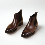 Homme assis portant des bottines Chelsea marron Dolcino avec pantalon élégant